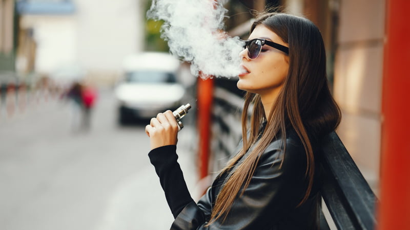 Lady in Black Leather and Shades Vaping Outside