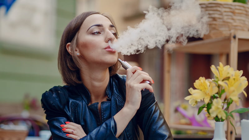 Woman Setting Vaping with Yellow Flowers on the Table