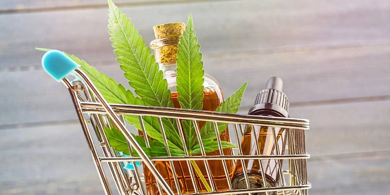 medical CBD oil and a cannabis leaf on a shopping cart