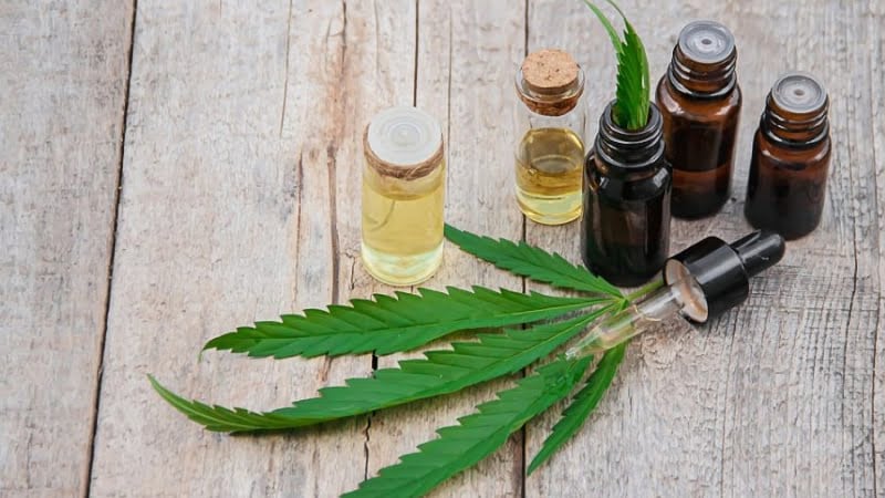 Cannabis extract in bottles and leaves on table