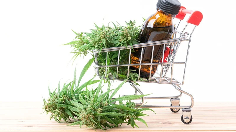 a shopping cart containing Delta8 extract in a bottle and hemp leaves 