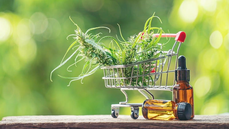 Hemp oil and leaves in a shopping cart