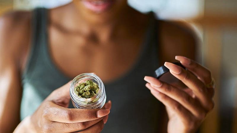 Image of a woman opening a bottle of legal marijuana from dispensary