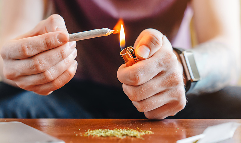 A guy lighting a joint