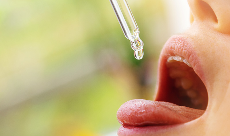 A girl putting CBG oil to her mouth