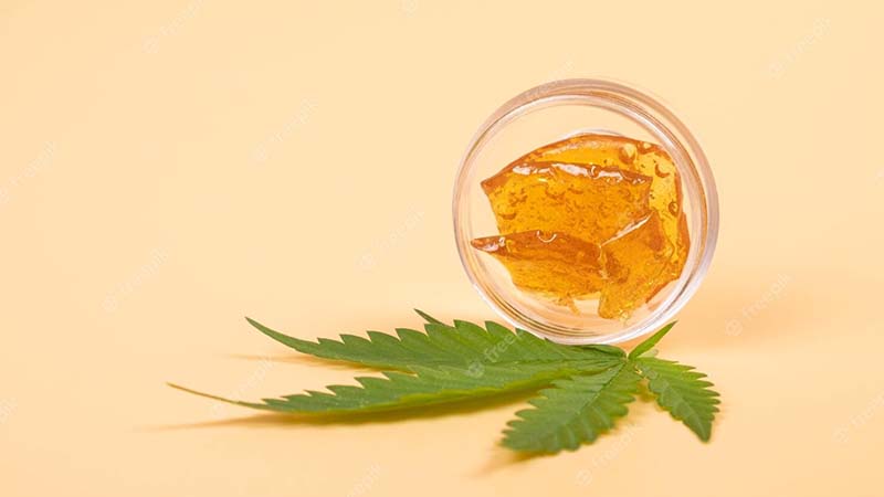 yellow cannabis wax and green-leaf marijuana concentrate