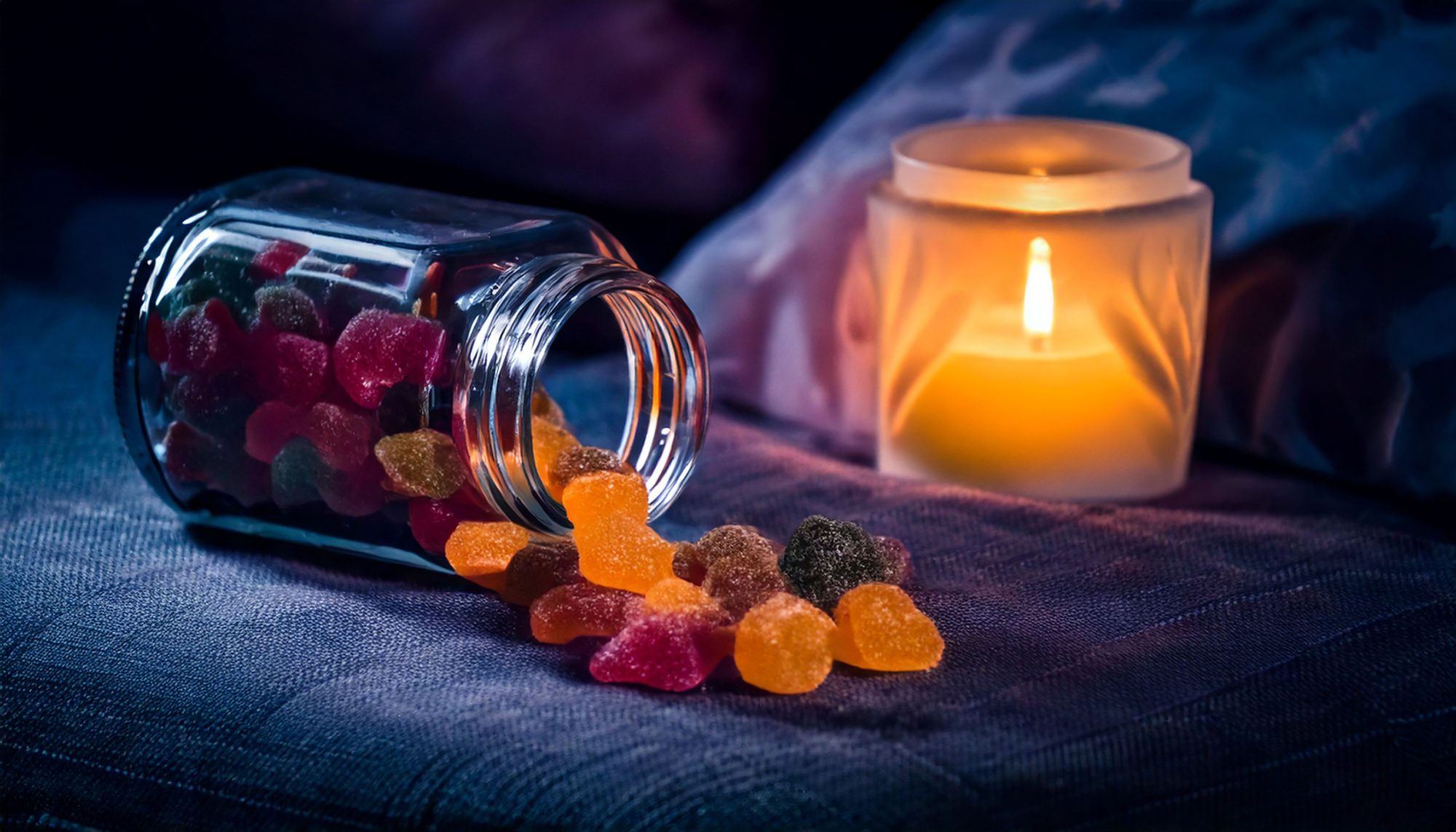 Indica THC gummies in a jar with a candle next to it